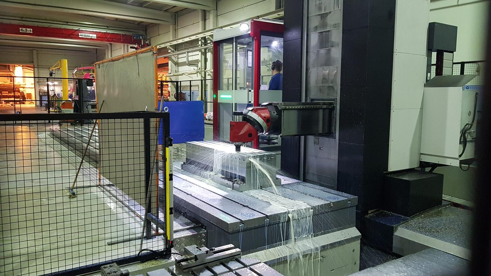 CNC-koneistusprosessi k&auml;ynniss&auml; RTA-Metallin tuotantotiloissa. J&auml;&auml;hdytysneste viilent&auml;&auml; metallikappaletta tarkkuuskoneistuksen aikana, varmistaen laadukkaan lopputuloksen.