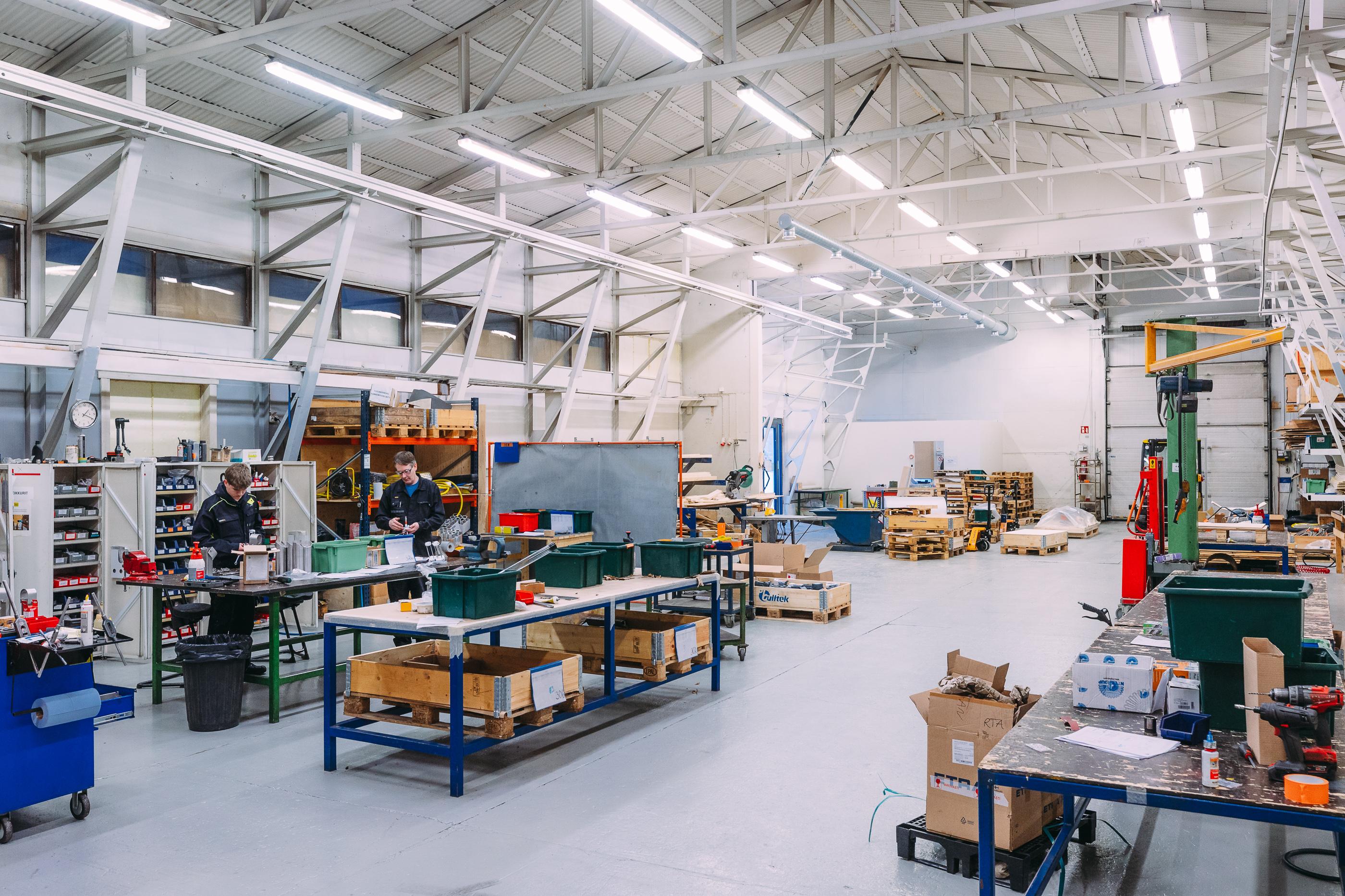 Tilava ja hyvin valaistu teollisuushalli, jossa kokoonpano- ja metallity&ouml;pisteit&auml;. Modernit ty&ouml;skentelytilat mahdollistavat tehokkaan valmistuksen ja logistiikan.