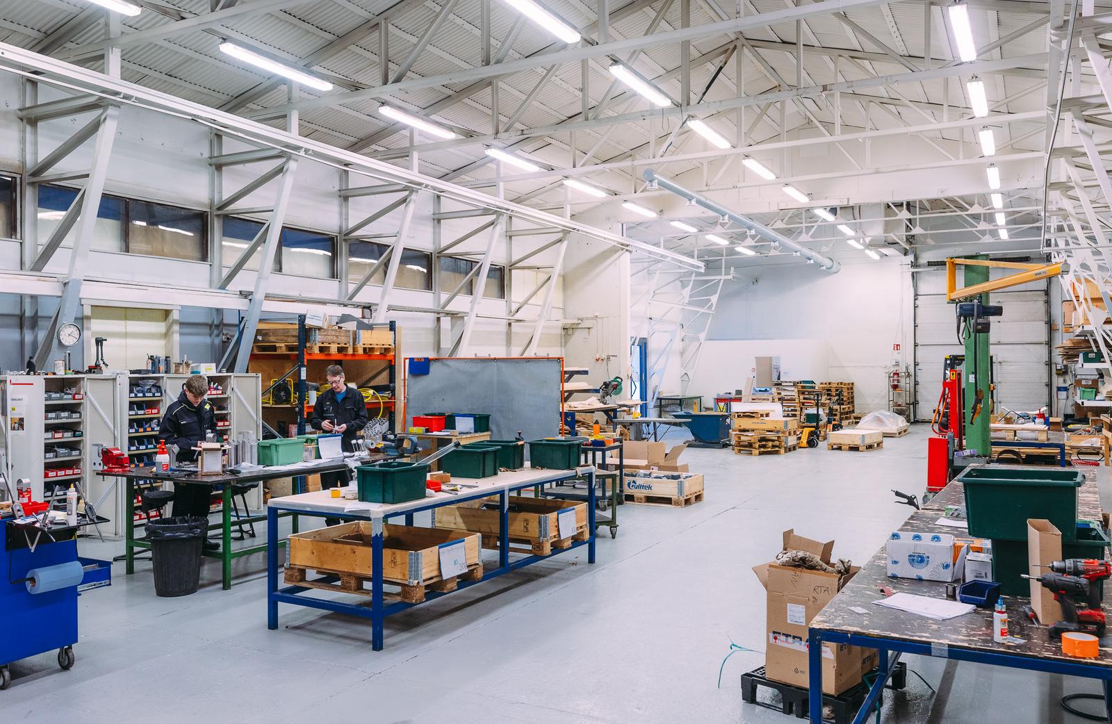 Tilava ja hyvin valaistu teollisuushalli, jossa kokoonpano- ja metallity&ouml;pisteit&auml;. Modernit ty&ouml;skentelytilat mahdollistavat tehokkaan valmistuksen ja logistiikan.